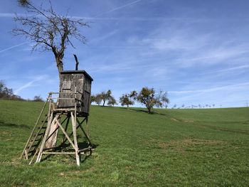 Traditional windmill on field against sky