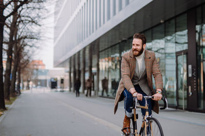 Portrait of man riding bicycle on street in city