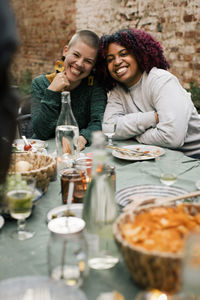 Portrait of multiracial female friends at dining table during dinner party