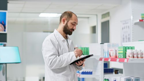 Side view of man using mobile phone in laboratory