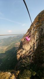 Woman on cliff against sky