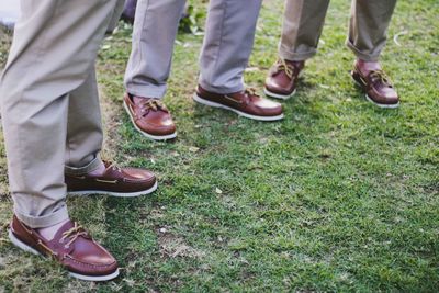 Low section of friends standing on field