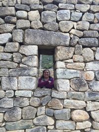 Portrait of girl sitting on stone wall