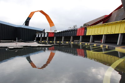 Reflection of built structure in lake against sky