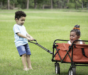 Little boy try playing fun with crying sister in park