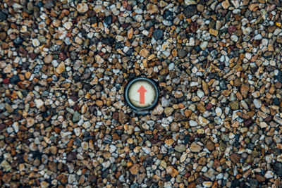 High angle view of arrow symbol on pebbles at beach
