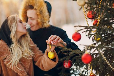 Close-up of woman decorating christmas tree