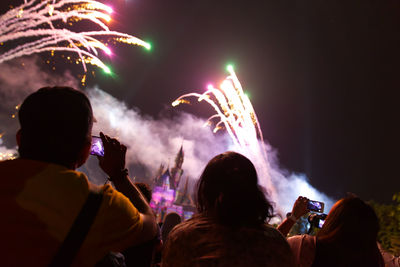 Rear view of people watching firework display