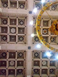 Low angle view of illuminated chandelier hanging in building