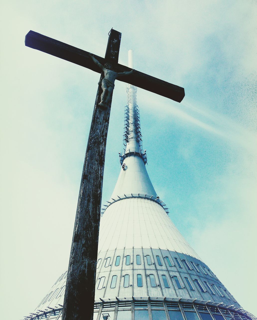 low angle view, architecture, built structure, sky, religion, tall - high, tower, building exterior, spirituality, place of worship, cloud - sky, cross, famous place, church, travel destinations, travel, spire, international landmark