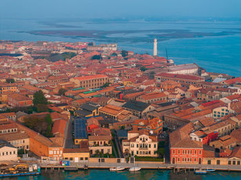 High angle view of townscape by sea against sky