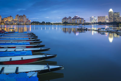 Scenic view of river by buildings against sky at dusk