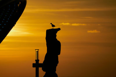 Low angle view of silhouette man standing against sky during sunset