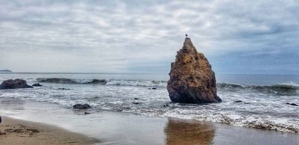 Rocks on beach against sky