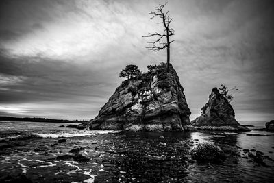 Rock formation on beach against sky