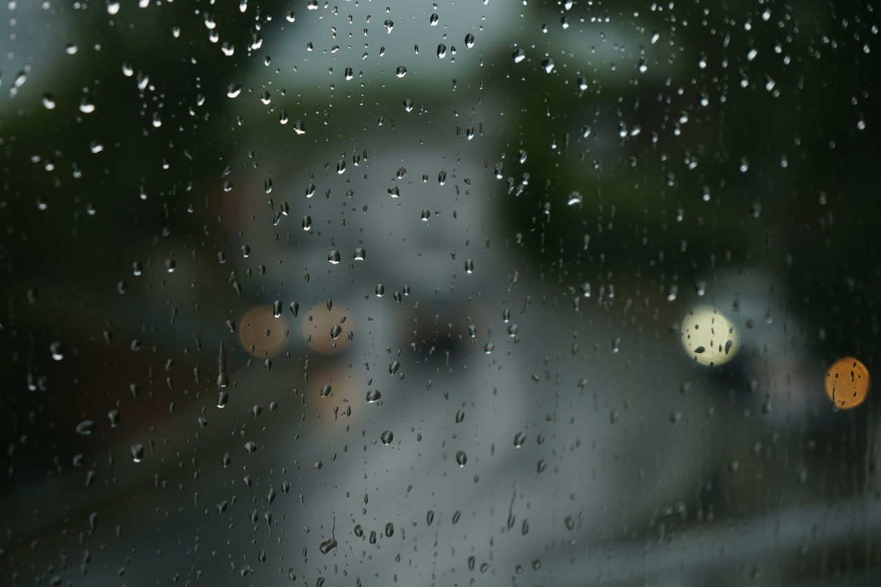 RAINDROPS ON GLASS WINDOW DURING RAINY SEASON