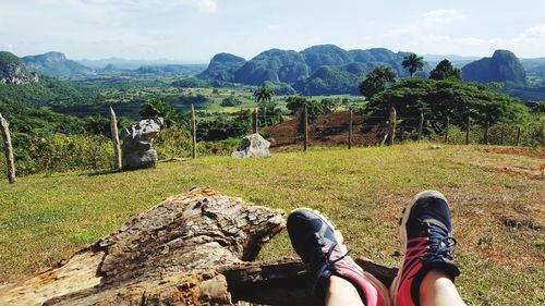 Low section of man standing on landscape against sky