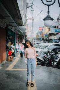Portrait of young woman walking on street