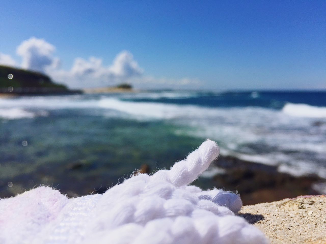 sea, water, beach, tranquil scene, tranquility, scenics, shore, surface level, nature, beauty in nature, frozen, sky, travel destinations, selective focus, vacations, tourism, non-urban scene, ocean, wave, blue, outdoors, focus on foreground, seascape, tide, coastline