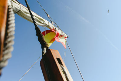 Low angle view of flags hanging against clear sky