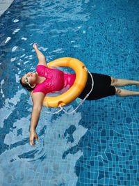 High angle view of woman floating in swimming pool