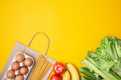 High angle view of bell peppers on yellow background