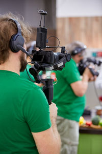 Midsection of man holding camera