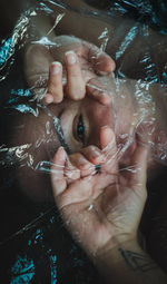 High angle view of woman tearing plastic apart  