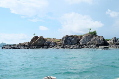 Rock formations in sea against sky