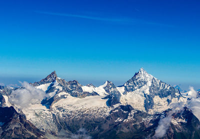 Scenic view of snowcapped mountains against clear blue sky