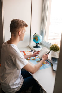 Young man sitting on table at home