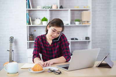Mid adult woman using laptop on table