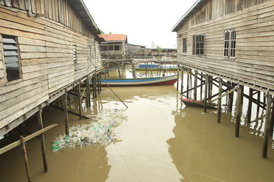 Canal amidst houses against sky