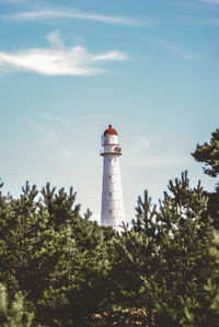 Low angle view of lighthouse by building against sky