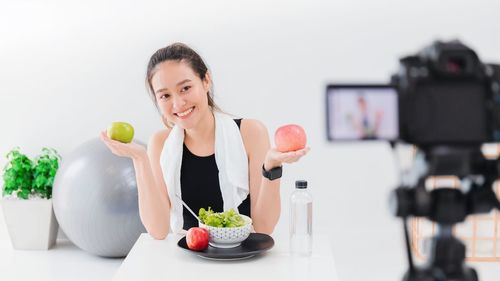 Portrait of young woman sitting on apple