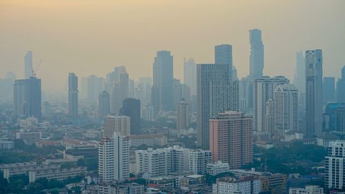 Aerial view of buildings in city against sky