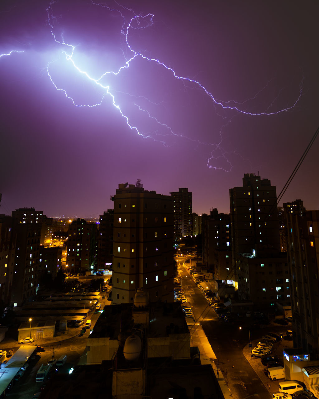 LOW ANGLE VIEW OF ILLUMINATED BUILDINGS AGAINST SKY