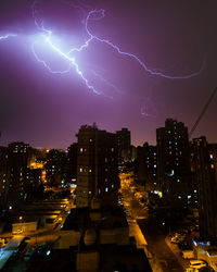 Low angle view of illuminated buildings against sky at night