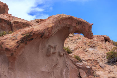 Low angle view of rock formation on land against sky