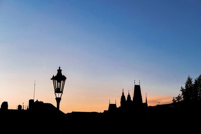 Low angle view of silhouette buildings against sky during sunset - charles bridge in prague 