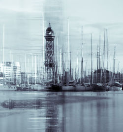 Sailboats in sea against buildings in city