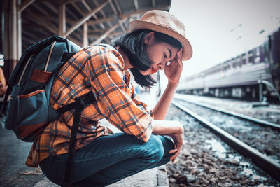 Woman sitting at railroad station platform