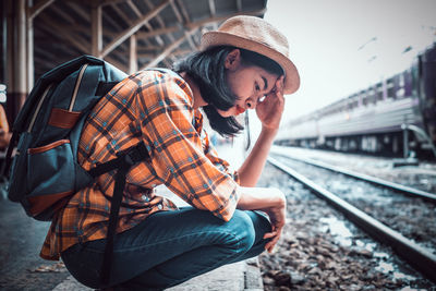 Young man looking down at railroad station