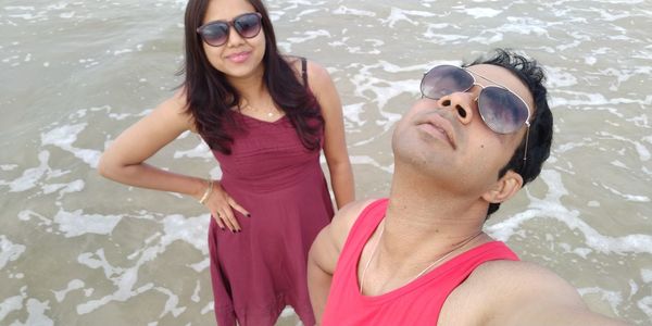 Portrait of couple in sunglasses at beach