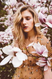 Young woman amidst pink flowers during springtime