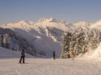 Tourists on snow covered mountain