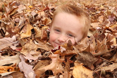 Close-up portrait of smiling girl with autumn leaves