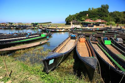 Boats moored on lake against clear sky