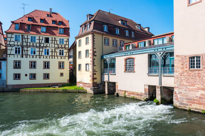 Buildings by river in city