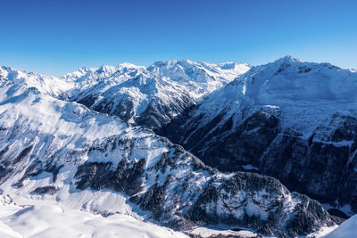 Scenic view of snowcapped mountains against clear sky